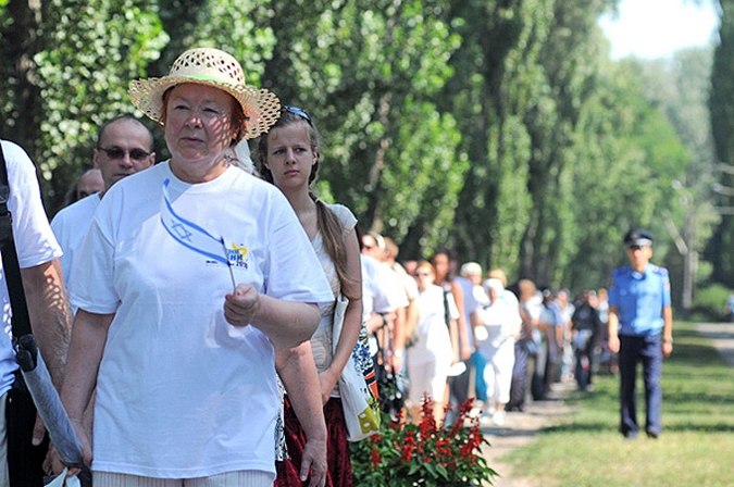 Люди скорбят по жертвам нацистских массовых убийств в Бабьем Яру, в окрестностях Киева, 5 августа 2010 года. 