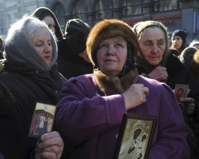 Группа русских православных верующих крестится во время митинга в знак протеста против введения единой электронной карты за пределами Московской городской Думы 9 марта 2011 года.