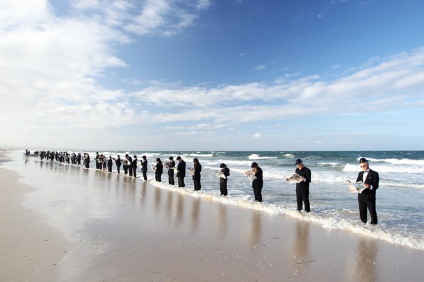 Массовое чтение газеты на пляже Хенли, Аделаида, Австралия, 8 января 2012 года