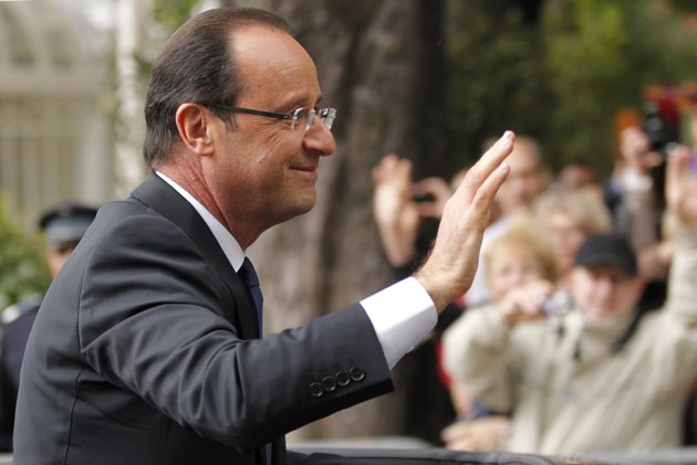 François Hollande, tout juste investi président de la République, salue la foule depuis sa voiture alors qu'il quitte le Palais de l'Elysée après la cérémonie d'investiture pour rejoindre l'Arc (630x421, 39Kb)
