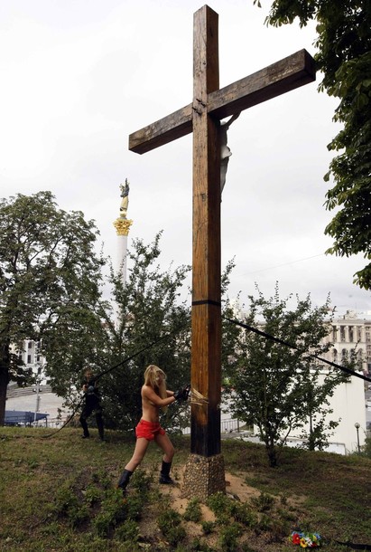 Активистка FEMEN спилила православный крест, воздвигнутый в память жертв политических репрессий, Киев, 17 августа 2012 года