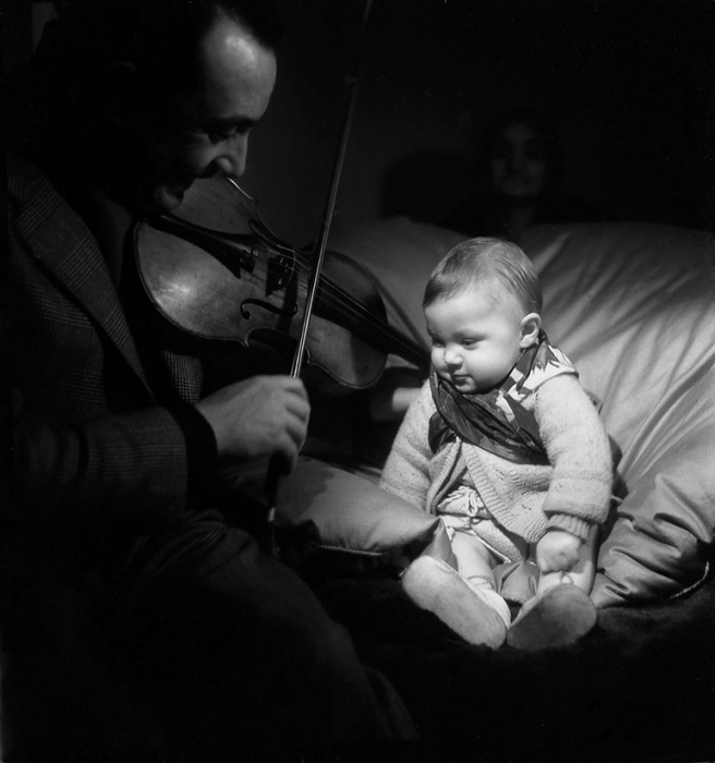Django Reinhardt plays the violin to his son Babik  1945 Émile Savitry.